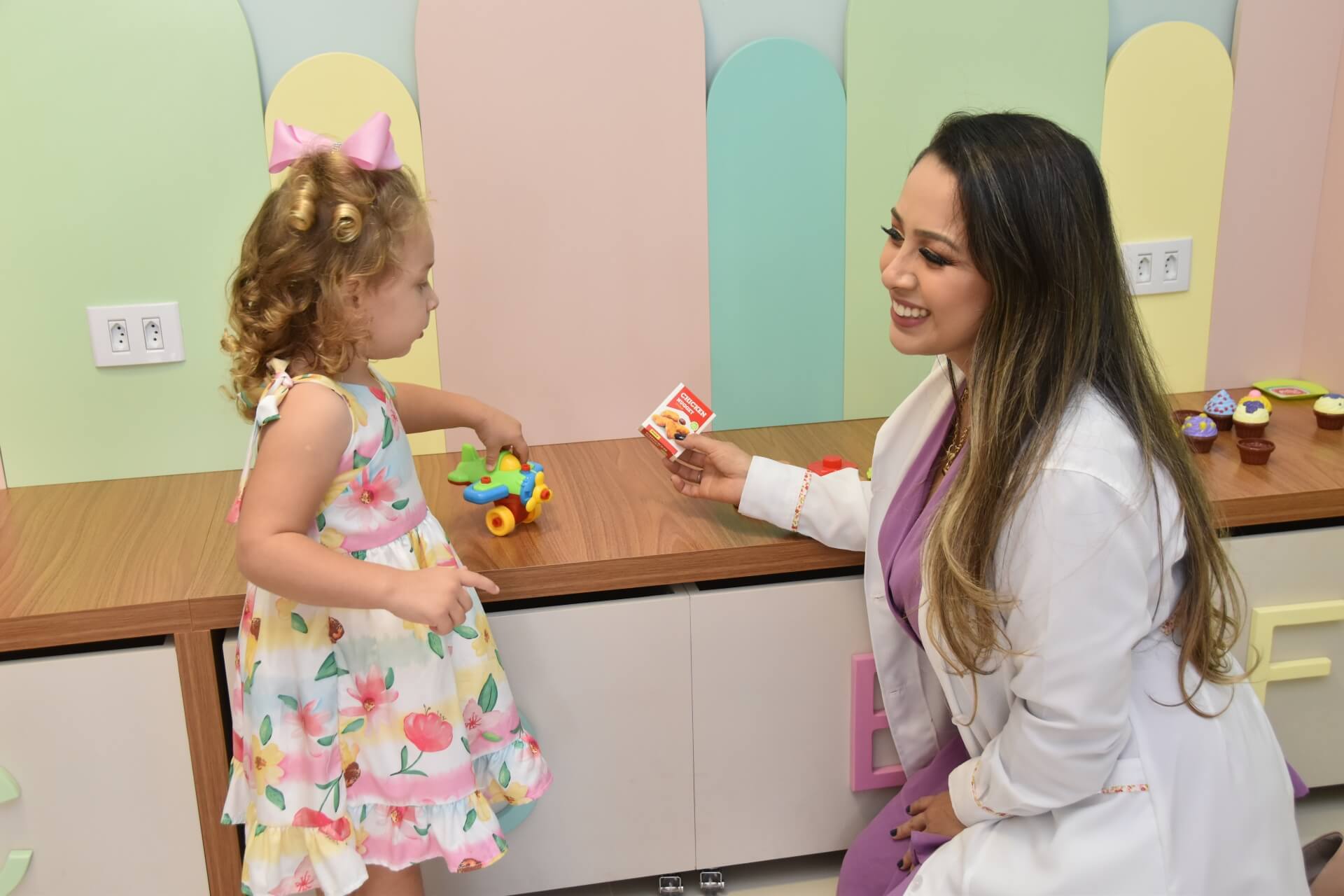 Vanessa realizando exame em bebê na sala de exames