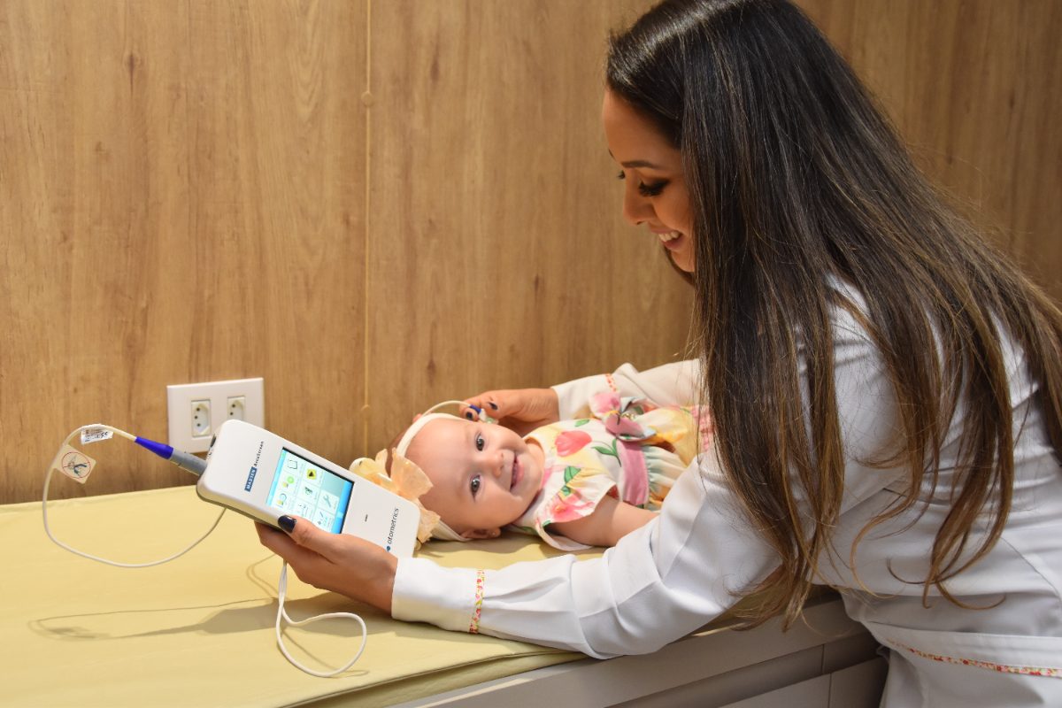 Vanessa realizando exame em bebê na sala de exames